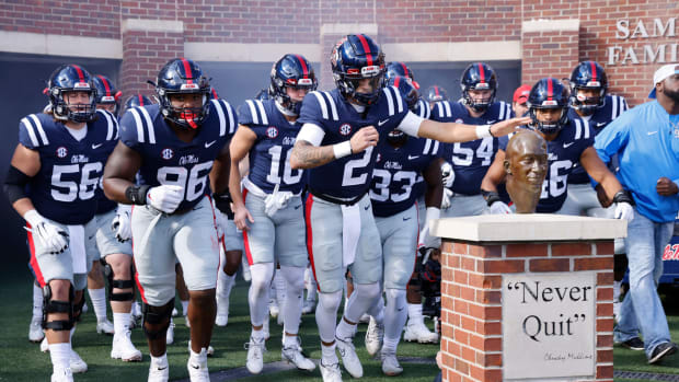 Quarterback Matt Corral leads Ole Miss out onto the field for a college football game against Liberty.