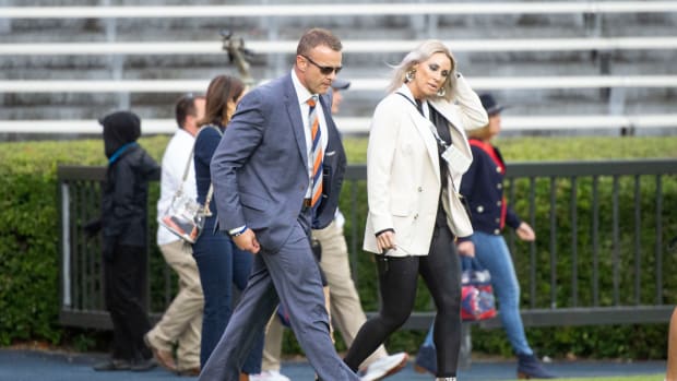 Bryan Harsin and his wife, Kes, walk across the field.