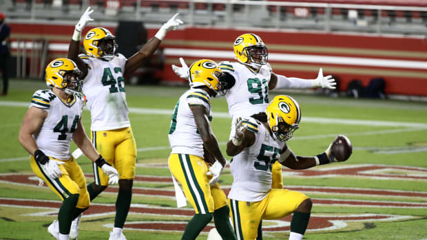 Green Bay Packers defenders including Za'Darius Smith celebrate a play.