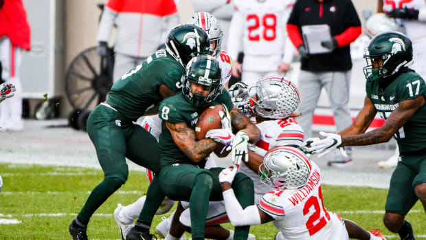 Ohio State players try too bring down Michigan State wide receiver Jalen Nailor.