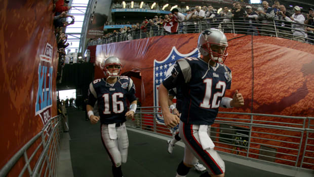 Matt Cassel and Tom Brady run out of the tunnel and onto the field.