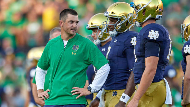 Notre Dame offensive coordinator Tommy Rees address players on the sidelines.