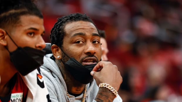 Rockets guard John Wall sits on the bench during a game.