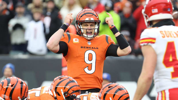Cincinnati Bengals quarterback Joe Burrow points at his helmet with both hands before snapping the ball.