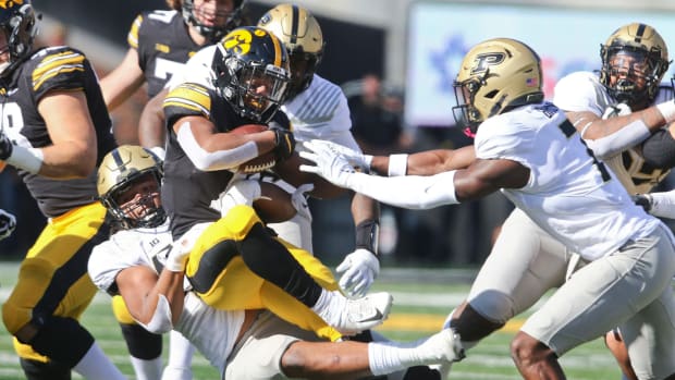 Iowa's running back is tackled by Purdue.