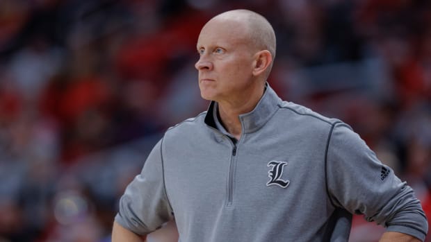 Louisville men's basketball head coach Chris Mack looks on with a frown.