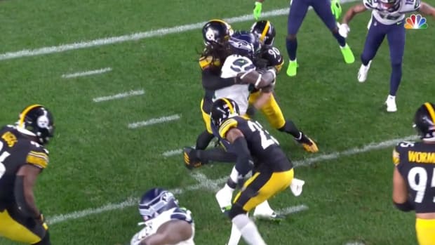 Pittsburgh Steelers' T.J. Watt punches at Alex Collins of the Seahawks.