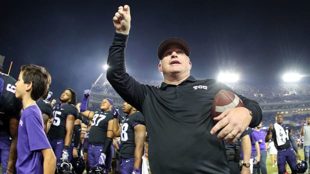 Head coach Gary Patterson of the TCU Horned Frogs holds his arm up as the band plays the alma mater after the 24-7 win over the Texas Longhorns.