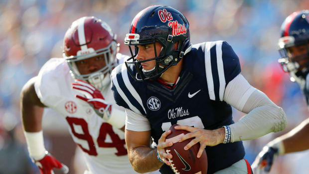 Chad Kelly tries to get away from an Alabama defender.
