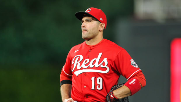 Joey Votto stands in the field with his hands on his hips.