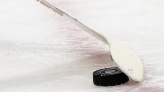 A goalie stick controlling the hockey puck