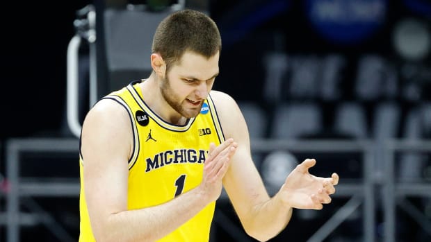 Michigan basketball big man Hunter Dickinson claps during a game against UCLA.