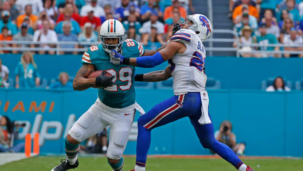 Arian Foster stiff arms a defender as he runs with the ball.