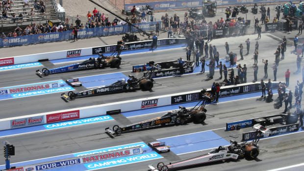 Four cars lined up at an NHRA event.