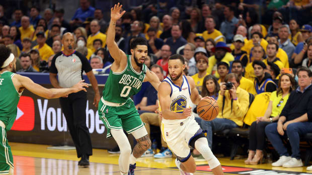 Steph Curry drives to the basket with Jayson Tatum guarding him.