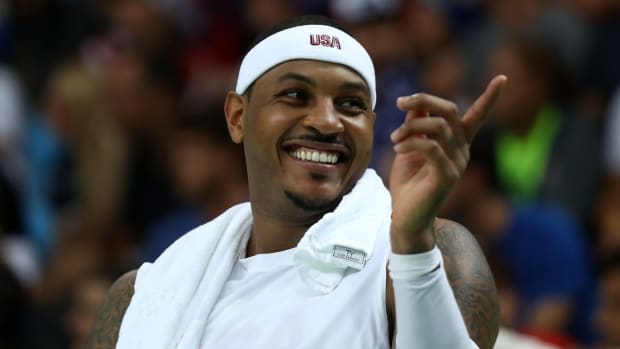 Carmelo Anthony smiling while on the bench for Team USA.