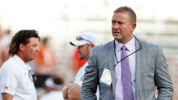 Kirk Herbstreit walks on the field before the college football game between Texas and Oklahoma State.