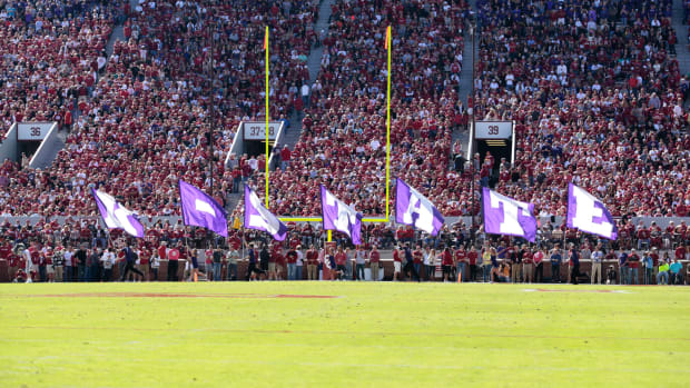 A picture of Kansas State's cheerleaders running with flags that spell out "K-State".