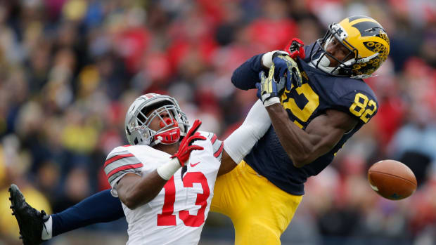An Ohio State football player deflecting a Michigan pass during a college football rivalry game.