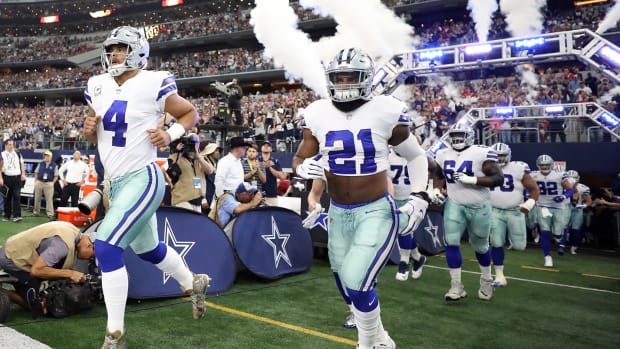 The Dallas Cowboys run onto the field before a game at AT&T Stadium.