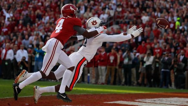 Alabama receiver Jerry Jeudy and an Auburn defensive back dive for a pass.
