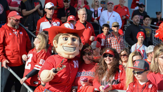 The Nebraska football mascot celebrates with fans in the stands against Iowa.