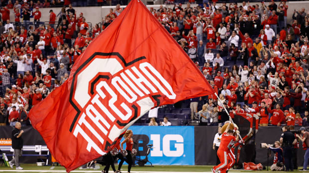 Ohio State cheerleader runs with team's flag at Big ten Championship.