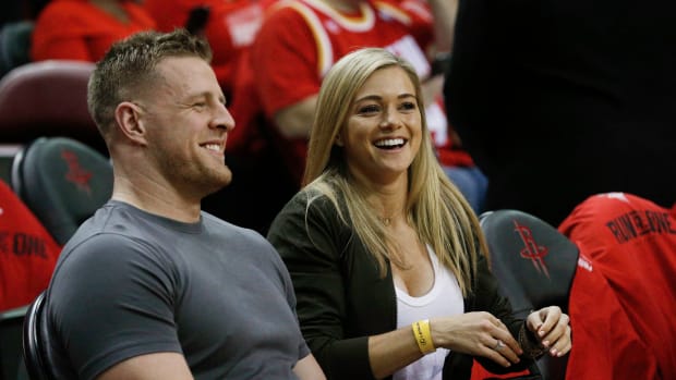 jj watt and his fiancee at a houston rockets game