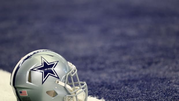 A Dallas Cowboys helmet sitting on the field.