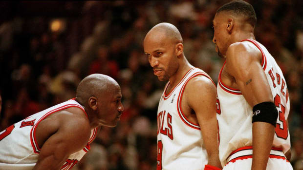 Michael Jordan talks with Scottie Pippen and Ron Harper during a game.