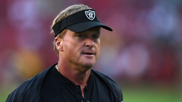 A closeup of Oakland Raiders coach Jon Gruden wearing a black visor.