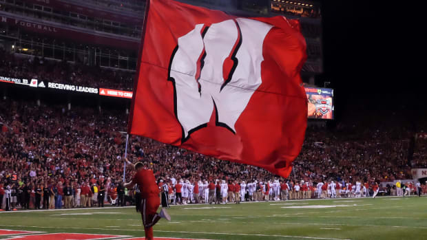Wisconsin flag bearer runs across the field.