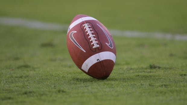 A closeup of a Nike football on the field during a game.