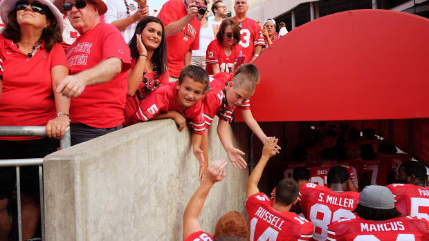 Ohio State players interacting with fans as they leave the field.