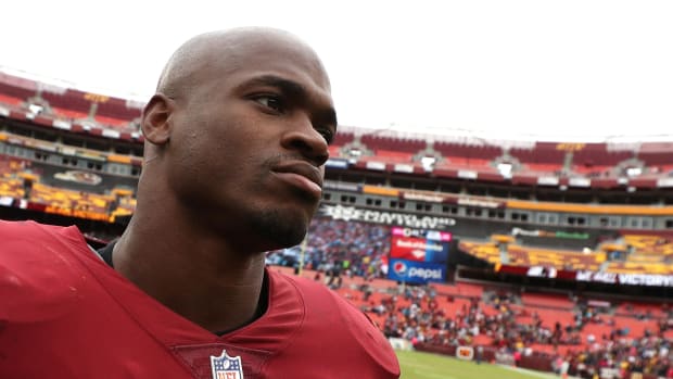 adrian peterson looks onto the field with the redskins