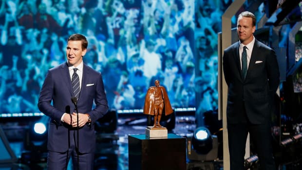 Eli and Peyton Manning on stage at an awards show.