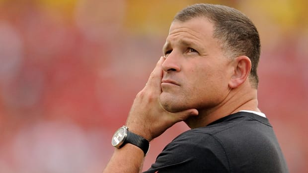 A closeup of Greg Schiano with his hand on his chin.