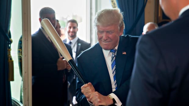 donald trump pretends to swing a baseball bat in the white house