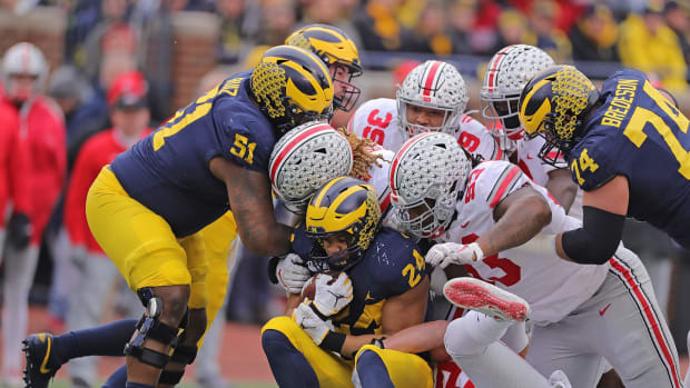 Big Ten rivals Ohio State and Michigan players during a college football game.