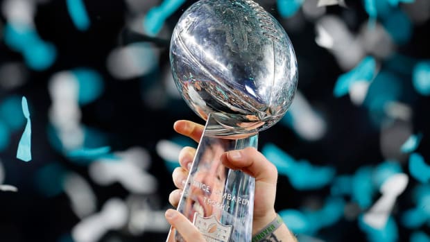 A closeup photo of the Super Bowl trophy with Eagles colored confetti in the background.