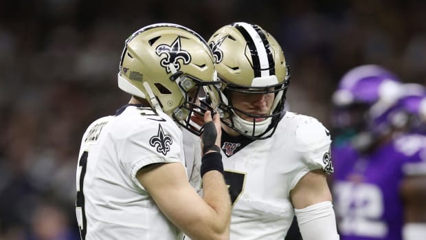 New Orleans Saints quarterbacks Taysom Hill and Drew Brees discuss a play during playoff game vs. the Vikings.