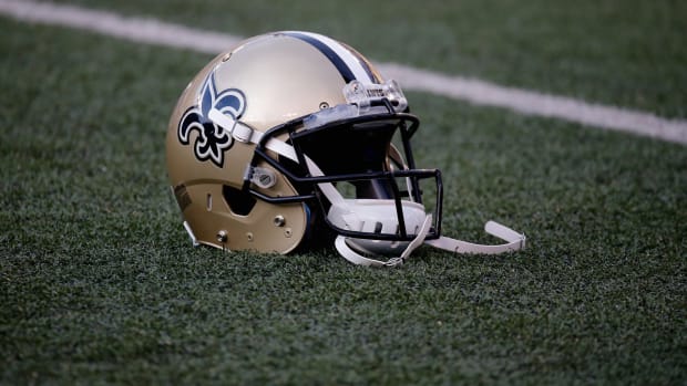 A New Orleans Saints helmet sitting on the field.