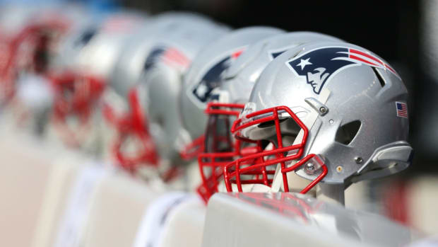 A New England Patriots helmet sitting on the bench.