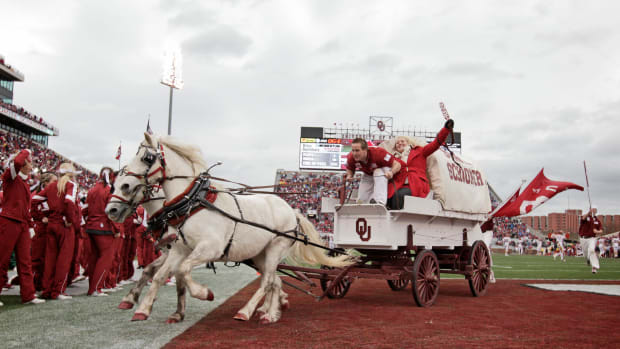 The Sooner Schooner being pulled off the field by two horses.