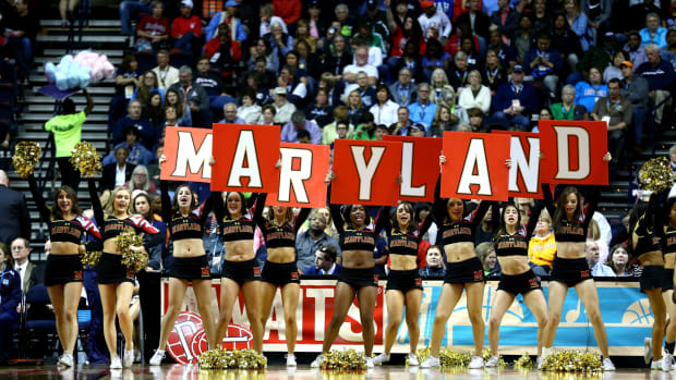 Maryland cheerleaders holding up signs that spell out Maryland.