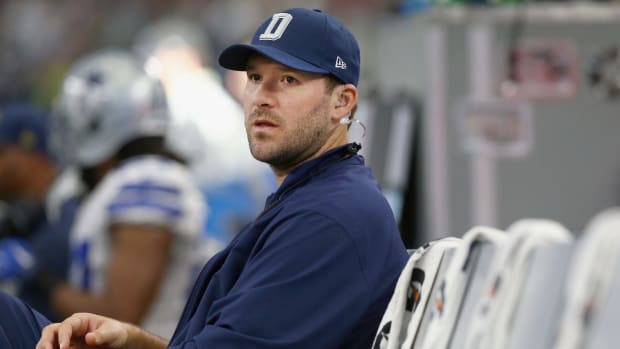 tony romo sits on the sideline during a game against the redskins