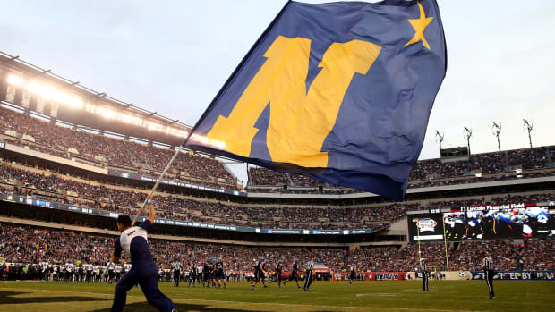 A Naval Academy cheerleader waving a flag during the Army-Navy Game in 2015.