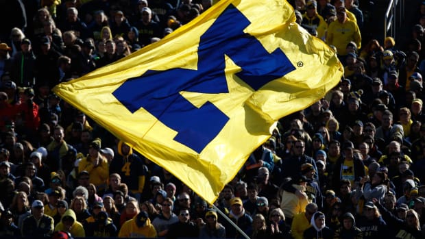 Fans watch a Michigan Wolverines flag after a score against the Illinois Fighting Illini.