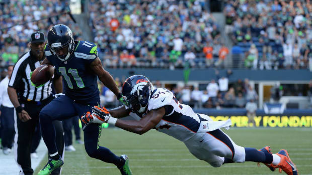 Percy Harvin avoids a tackle from a Denver Broncos defender.