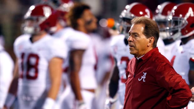 Head coach Nick Saban of the Alabama Crimson Tide watches the team warm up before the first half of an NCAA football game against the Mississippi State Bulldogs.
